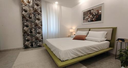 a bedroom with a bed with white sheets and pillows at La Ginestra Dell' Etna in Adrano