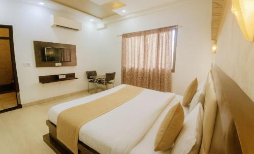 a bedroom with a large bed and a television at Hotel SoT Intn premium Near TajMahal in Agra