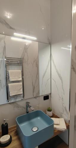 a bathroom with a blue sink and a mirror at La Ginestra Dell' Etna in Adrano