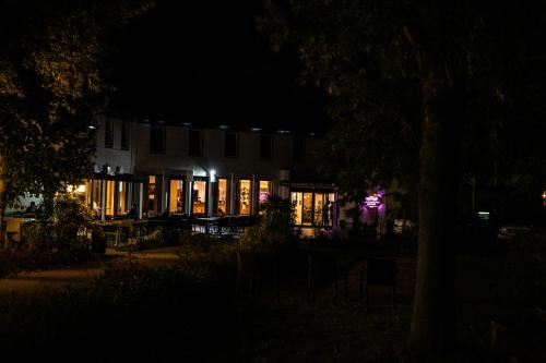 a building lit up at night with lights at Hotel De Elderschans in Aardenburg