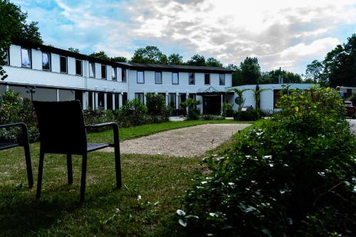 a chair sitting in the grass in front of a building at Hotel De Elderschans in Aardenburg