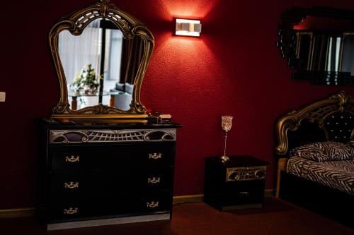 a bedroom with a dresser with a mirror and a bed at Hotel De Elderschans in Aardenburg