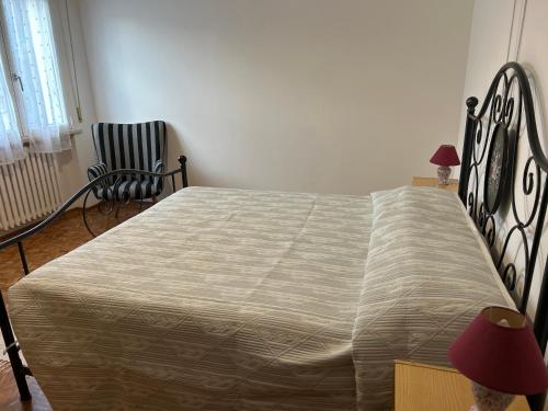 a bedroom with a bed and a chair and a lamp at Casa di Paolo in Castrocaro Terme