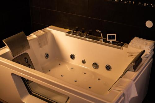 a bath tub with a sink in a bathroom at Hotel De Elderschans in Aardenburg