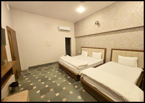 a room with two beds in a room at HOTEL C-D-P NARAYANA - Peaceful & Comfortable Stay Near Kashi Vishwanath Temple in Varanasi