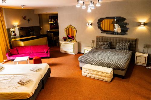 a hotel room with two beds and a couch at Hotel De Elderschans in Aardenburg