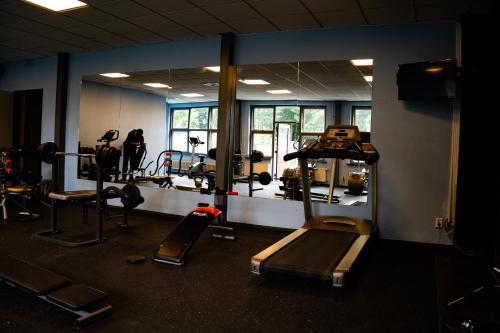a gym with treadmills and machines in a room at Hotel De Elderschans in Aardenburg