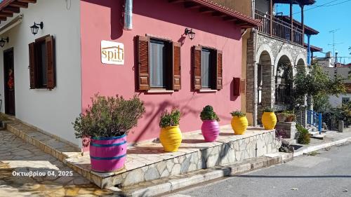 a row of potted plants inront of a pink building at Spiti Ouranoupoli in Ouranoupoli