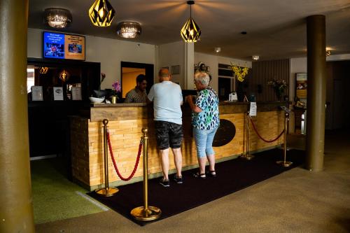 a couple of people standing at a bar at Hotel De Elderschans in Aardenburg