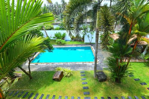 an overhead view of a swimming pool in a yard with palm trees at oZean Villa in Talpe