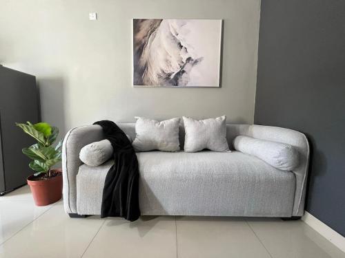 a living room with a couch with a blanket on it at Trendy Homes in Gaborone