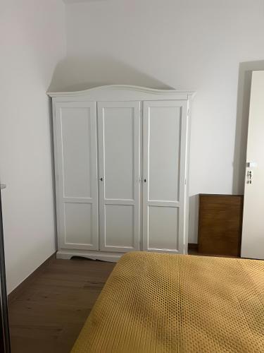 a bedroom with white cabinets and a bed at Dente Di Leone in San Mauro Cilento