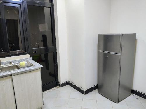 a kitchen with a stainless steel refrigerator next to a window at Panoramic Three Bedrooms Apartment in Addis in Addis Ababa