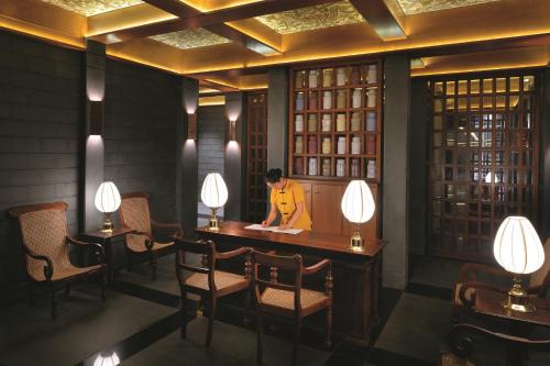 a man standing at a table in a room with lights at Gokulam Grand Hotel & Spa Bangalore in Bengaluru