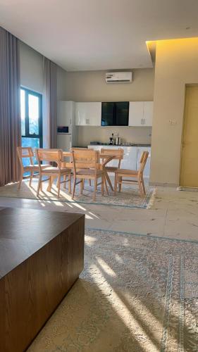 a living room with a table and chairs and a kitchen at Dirat Al-Ghizal 2 in Ras al Khaimah