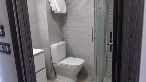 a bathroom with a toilet and a glass shower at Hostal Goyma III in San Fernando de Henares