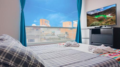 una camera da letto con un letto e una grande finestra di centro de pasto apartamento kz a Pasto