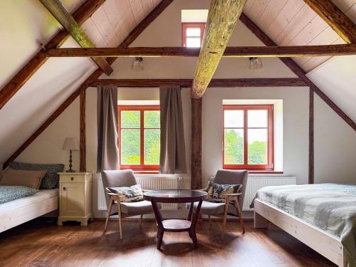 a bedroom with a bed and a table and chairs at Chalupa mezi stezkami in Hejnice