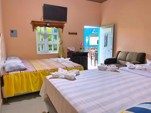 a bedroom with two beds and a tv on the wall at Habitación El Paredon in El Paredón Buena Vista