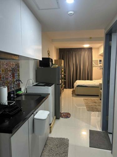 a kitchen with a counter and a room with a bed at J&W's JTower Residences Condominium in Mandaue City