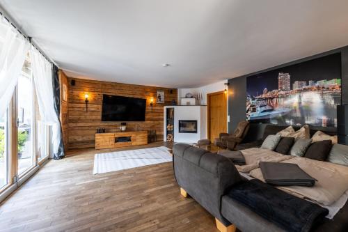 a living room with a couch and a tv at Ferienhaus Goldener Anker Unterach am Attersee in Unterach am Attersee