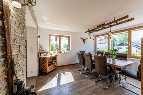 a dining room with a stone wall and a table and chairs at Ferienhaus Goldener Anker Unterach am Attersee in Unterach am Attersee