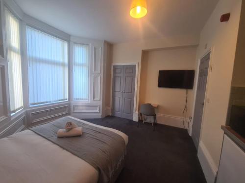 a woman sitting on a bed in a bedroom at Athol apartments in Sunderland