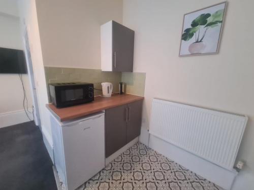 a small kitchen with a microwave on a counter at Athol apartments in Sunderland