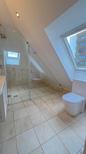 a attic bathroom with a toilet and a window at Key Inn Appart Hotel Belair in Luxembourg