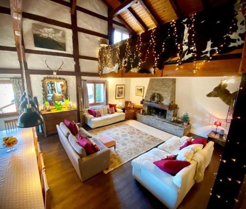 sala de estar amplia con 2 sofás y chimenea en Alpine Chalet with Mountain Views, en Les Gets