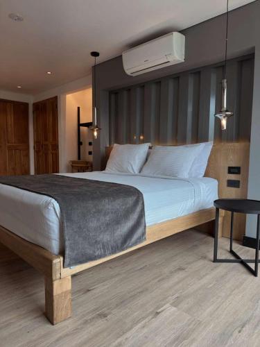 a bedroom with a large white bed and a chair at Hotel Casa Victoria in Medellín
