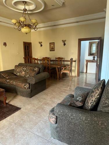 a living room with couches and a dining room at Family apartment in Amman 3 bedrooms in Amman