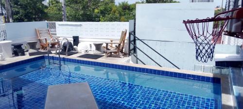 a swimming pool with a basketball hoop on a building at BEN & LEK GUESTHOUSE in Pattaya South
