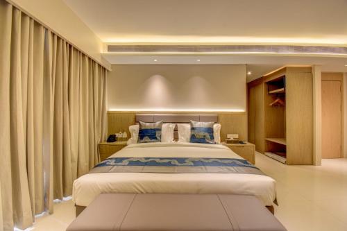 a large bedroom with a large bed with curtains at The SSK Solitaire Boutique Hotel and SPA in Nashik