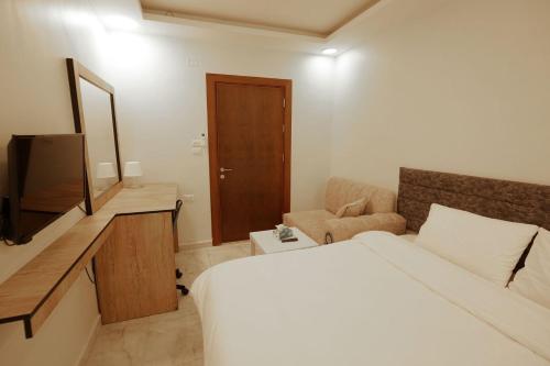 a hotel room with a bed and a television at النخيل للاجنحة السكنية Nakheel Suites in Irbid
