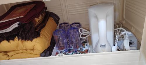 a group of glass vases sitting in a drawer at Roomstay Cheq Ayoh Pantai Penarik Setiu in Kampong Ru Sepuloh