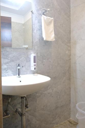 a bathroom with a sink and a mirror at Hotel Ram Janki Inn Ayodhya in Ayodhya