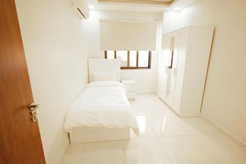 a white room with a bed and a window at النخيل للاجنحة السكنية Nakheel Suites in Irbid