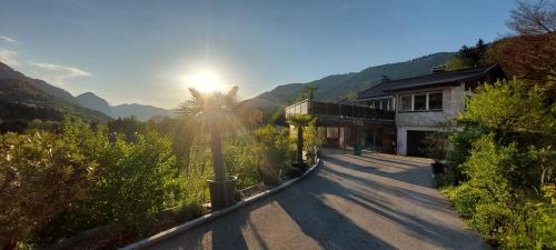 a house with the sun shining down on a road at Ferienhaus Goldener Anker Unterach am Attersee in Unterach am Attersee
