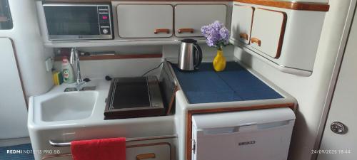 een kleine keuken met een spoelbak en een magnetron bij Marina Yatch Hostel in Lissabon