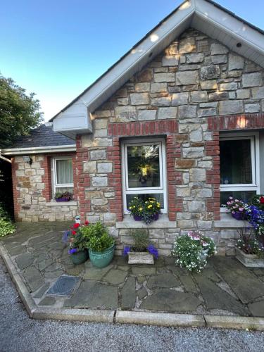 una casa de ladrillo con flores delante en Reads Park No 2, en Galbally