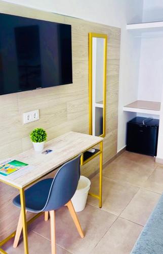 a wooden desk with a blue chair and a table at DORI ROOMS - Hostal in Tarifa