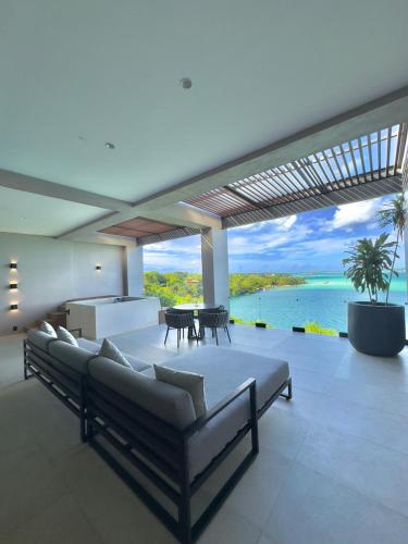 a living room with couches and a view of the ocean at Amaranto Bacalar Hotel Boutique in Bacalar
