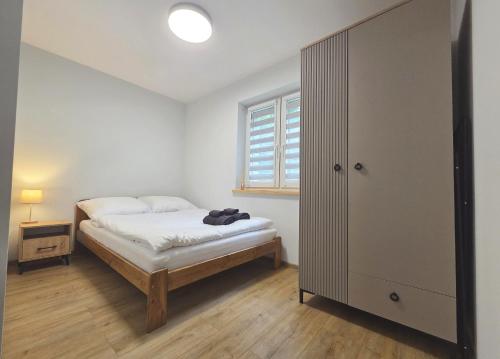 a small bedroom with a bed and a window at EIRA Apartament - Self check-in in Szklarska Poręba