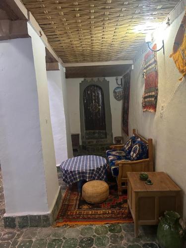 a living room with couches and tables in a room at Kasbah Ziwana - Guesthouse in Zagora