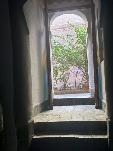 an open doorway to a building with a tree outside at Kasbah Ziwana - Guesthouse in Zagora