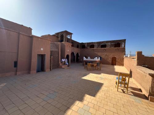 a patio in a building with a table and chairs at Kasbah Ziwana - Guesthouse in Zagora