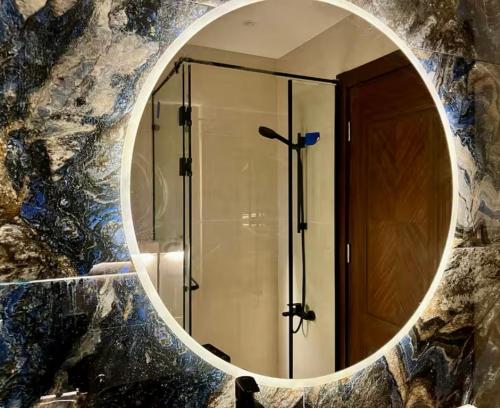 ein Badezimmerspiegel mit Dusche und Glastür in der Unterkunft Diva 2BDR , Madinaty in Madinaty