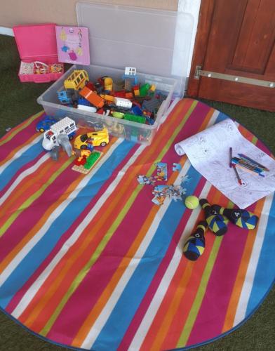 a plastic container with toys on top of a rug at Berek Vendégház Fonyód in Fonyód