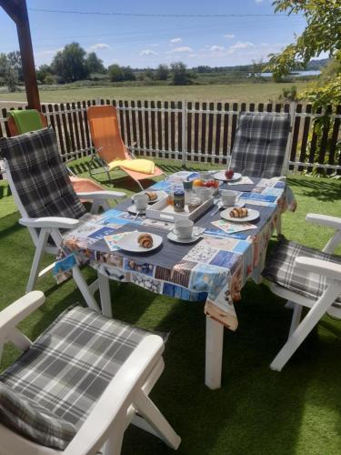 a table and chairs with food on a patio at Berek Vendégház Fonyód in Fonyód